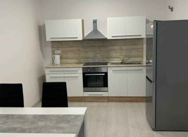 A kitchen with a dining table in a 2-room apartment with modern furnishings.
