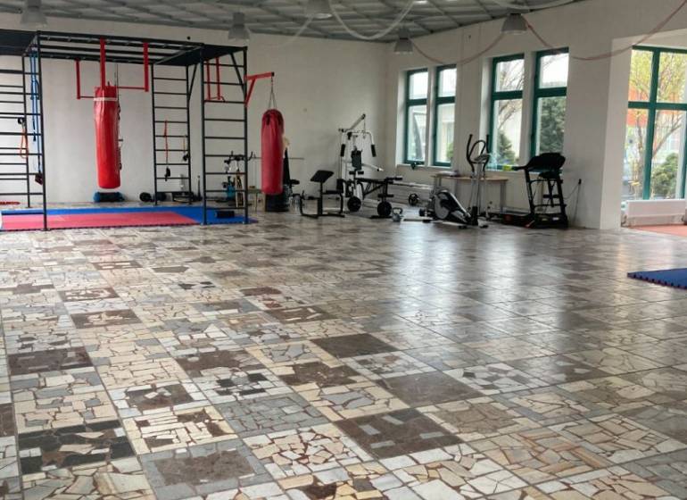 Spacious offices with punching bags and fitness equipment, flooring made of various types of marble.