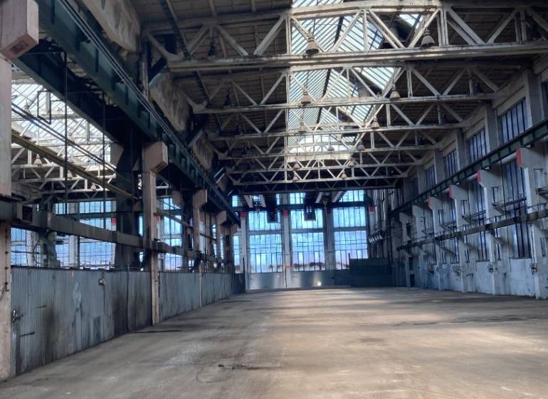 Industrial warehouses and halls with steel structures and glass roofs.