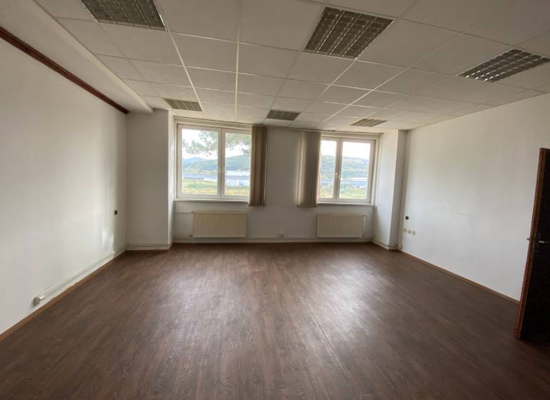 Office space with a dark floor and a window with a view.