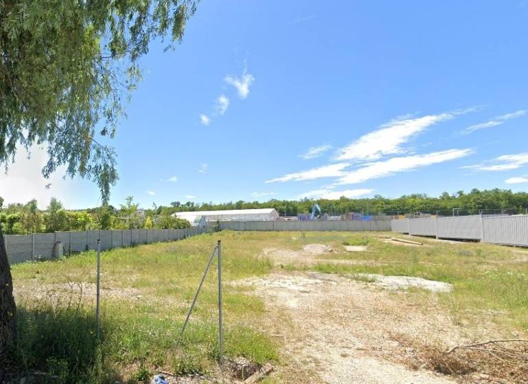 Plots - commercial in Nitra, grassy area with fencing and blue sky.