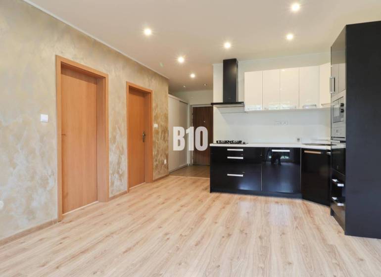 Interior of a 3-room apartment with a bright kitchen and wooden flooring.