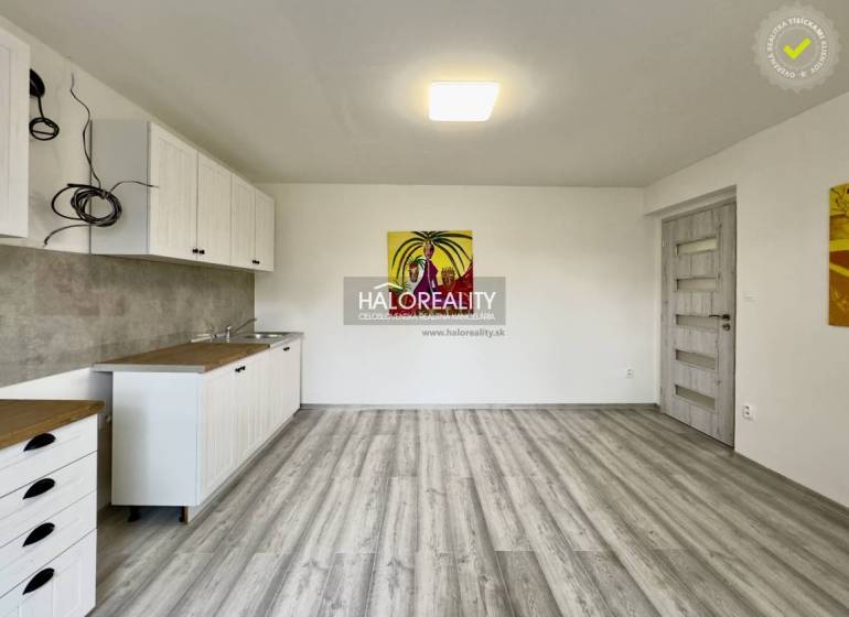 Interior of a family house with a kitchen unit and an abstract painting on the wall.