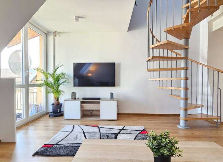 Living room with a television, staircase, and a plant in a 4-room apartment.