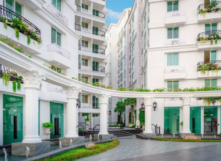 Apartment construction in Pattaya with elegant white buildings and Greek columns.