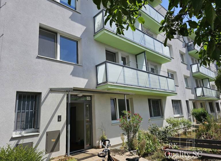 A residential building on Žitavská Street in Senec surrounded by greenery with glass balconies.