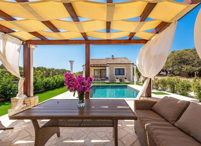 A family house in Bibinje with a gazebo, a pool, and a beautiful garden seating area.