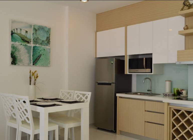 Kitchen and dining area in a 2-room apartment with four chairs and decoration.