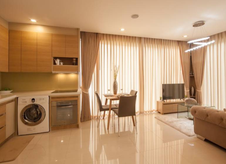 2-room apartment with a kitchen, living room, and dining area, with light-filtering curtains.