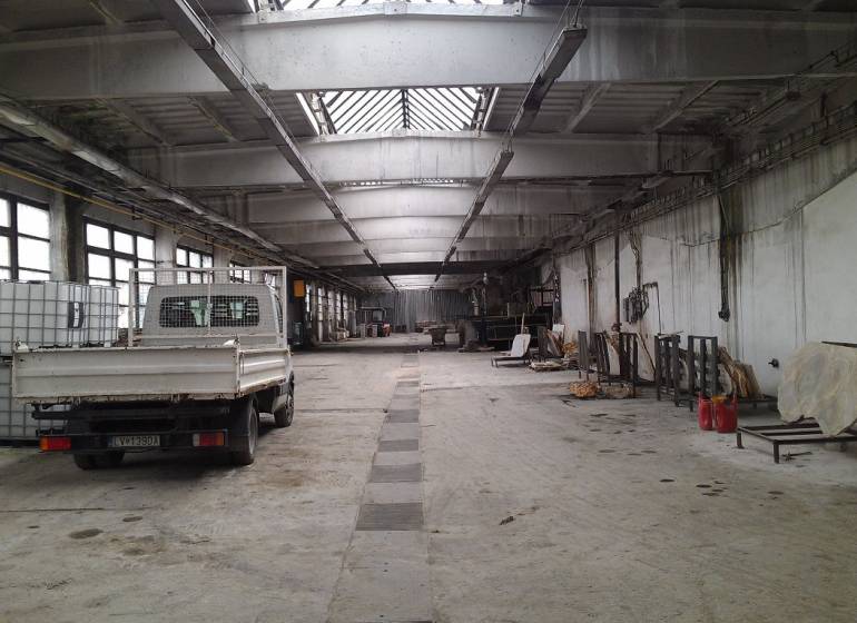 A spacious hall with a parked car and storage tanks in Levice.