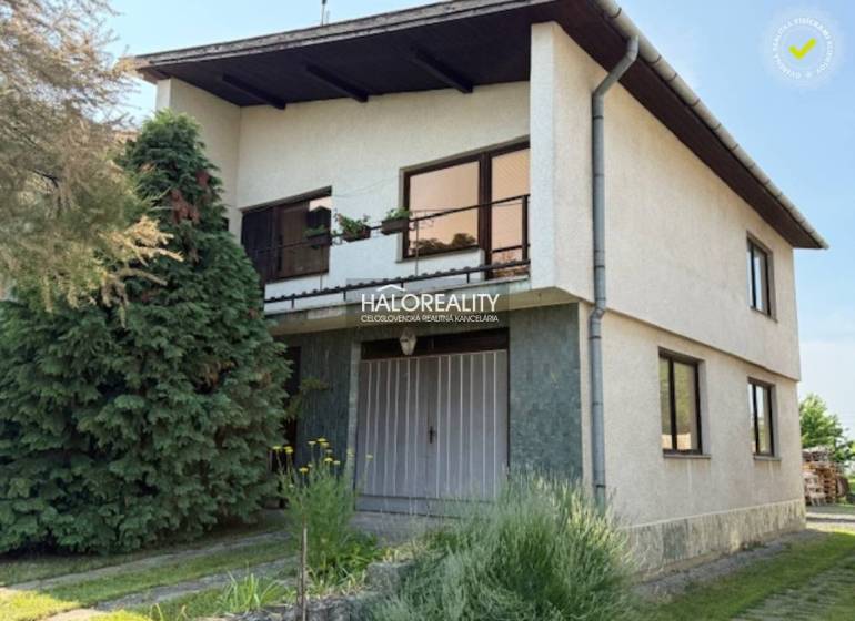 A family house in Borša with two floors, a garden, and coniferous trees.