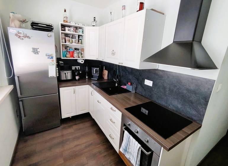 A kitchen in a 2-room apartment, equipped with appliances and storage space.