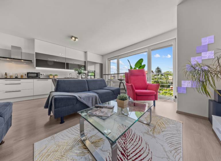 Living room with a sofa and an armchair in a 4-room apartment. Large windows with a view.