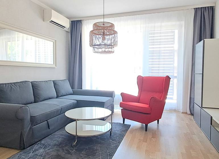 Living room with a comfortable sofa, a red armchair, and a television in a two-room apartment.
