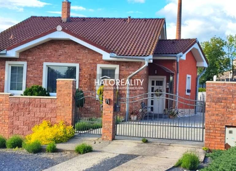 A family house in Kalinovo with a brick facade, decorative fence, and garden features.