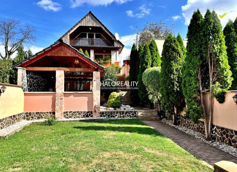 A family house in Levice with a landscaped garden, a gazebo, and trees.