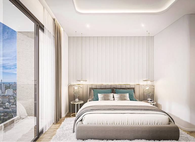 A bedroom in a 2-room apartment with a view of the Pattaya city skyline.