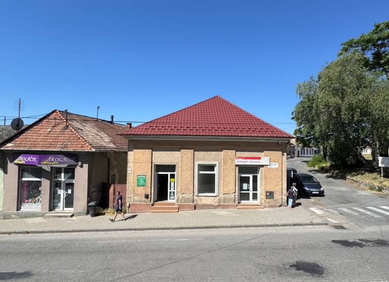 Commercial premises on the Main Square in Šahy with a red roof and blue sky.