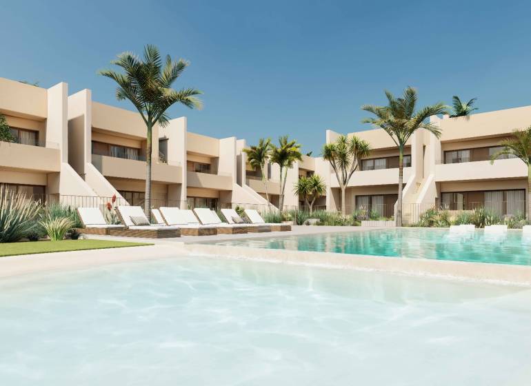 Pool and loungers in the complex of 4-bedroom apartments in the town of Roda with palm trees.