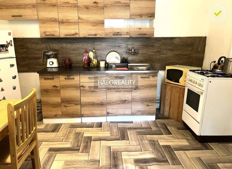 A kitchen in a family house with wooden cabinets, a stove, and a refrigerator.