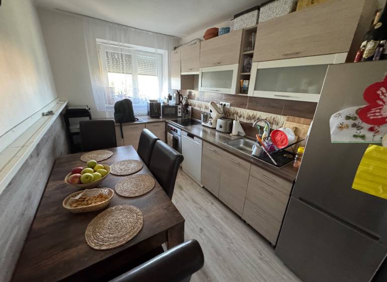 A kitchen with a dining table and a modern kitchenette in a 3-room apartment.