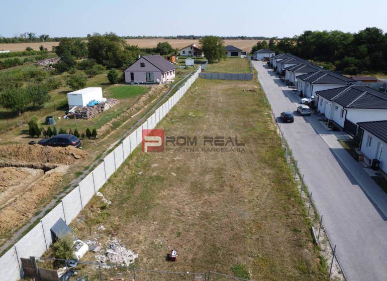 Plots - housing in Štefanová, next to an empty parcel, surrounded by rural houses and greenery.