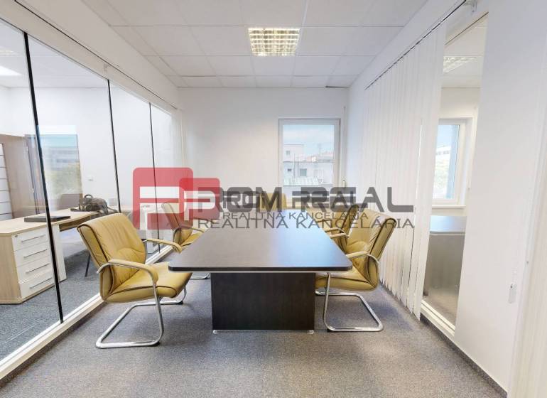 Modern offices with glass partitions, light furniture, and windows.