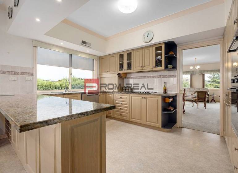 A spacious kitchen with an island and a dining table in a 3-room apartment.