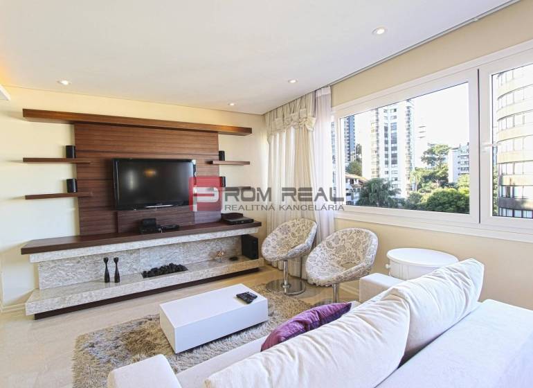 Living room in a 3-room apartment, with a TV and large windows offering a view.