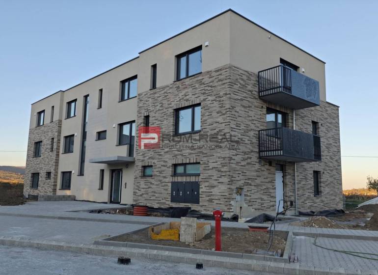 A new building with a brick facade on the street in Pezinok includes 2-room apartments.