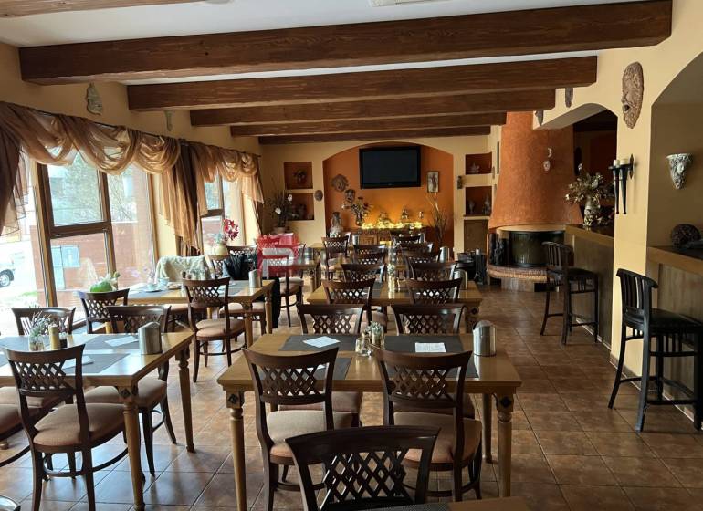 Restaurant with wooden ceilings, floral decoration, and a fireplace, category Hotels and Inns.