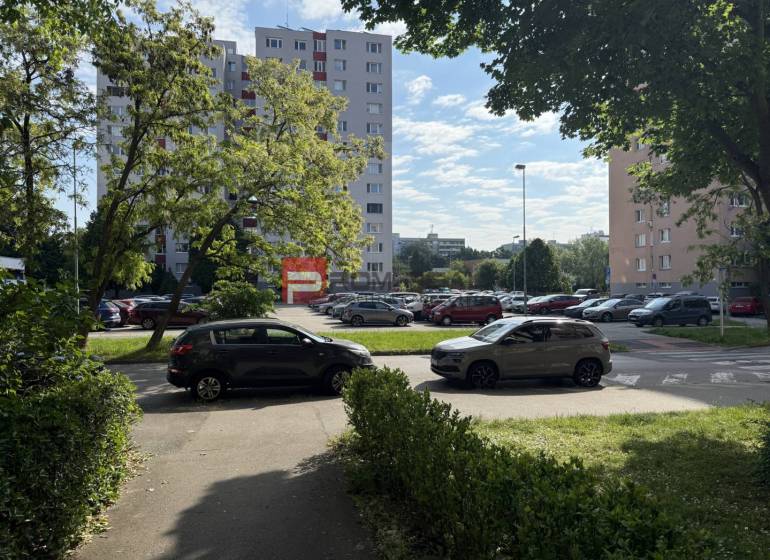 A view of apartment buildings and a parking lot, surrounded by greenery on Hrobákova in Bratislava V.