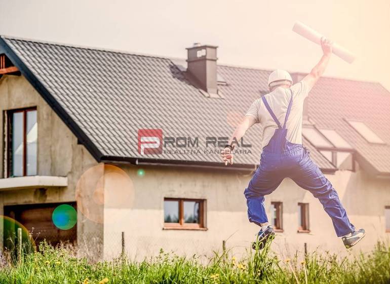 A builder happily jumps in front of the house, holding construction plans. Construction and a 1-bedroom apartment.
