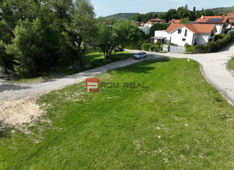 A residential plot in Marianka on Na tálkoch street surrounded by greenery and a road.