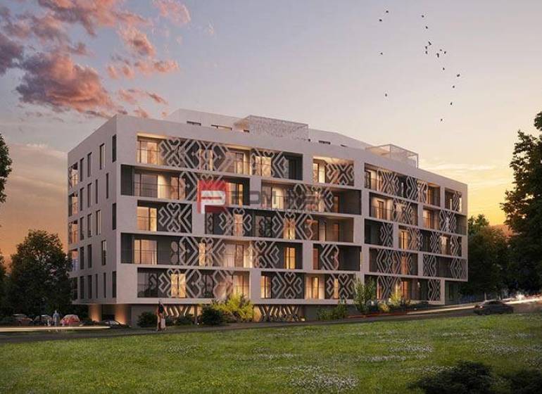 A modern apartment building in Bratislava III with evening lighting and green surroundings.