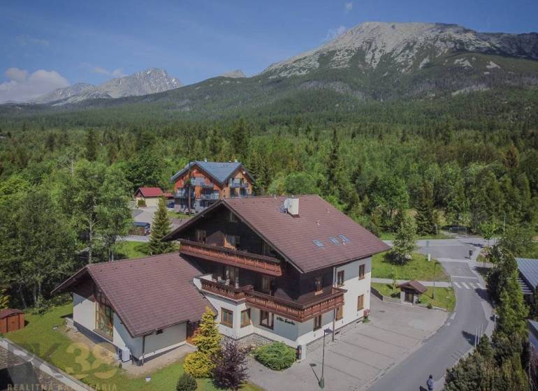 Recreational apartments in the High Tatras, surrounded by dense forest and majestic mountains.