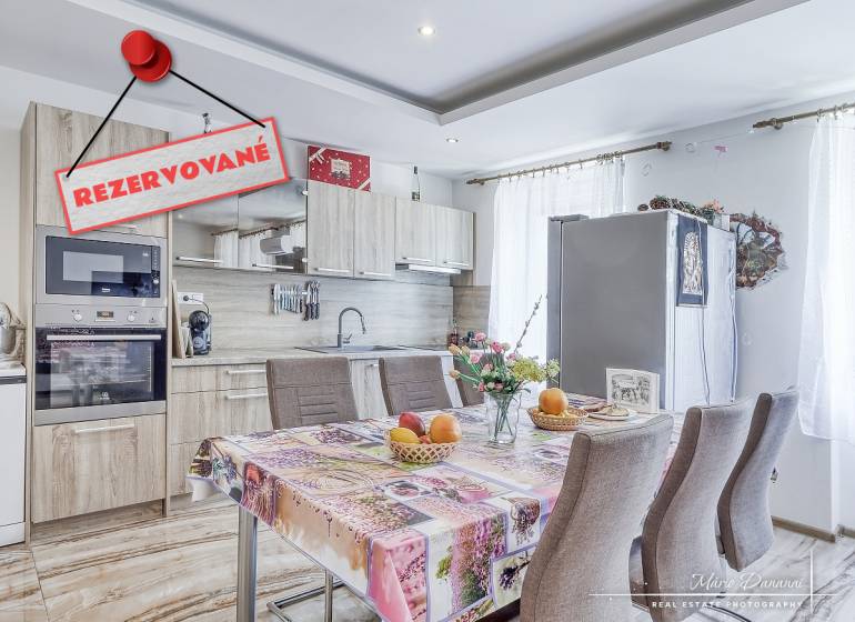 A kitchen in a 2-room apartment with a table, appliances, and a 