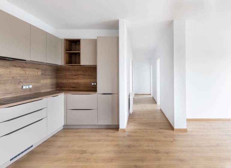 A kitchen with wooden elements and a hallway in a 3-room apartment, bright and minimalist solution.
