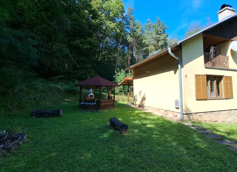 Cottage on Dobra in Kvakovce with a gazebo by the forest and a manicured lawn.