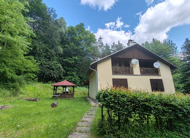 The cottage on Dobra in Kvakovce, surrounded by greenery, near the forest and the gazebo.
