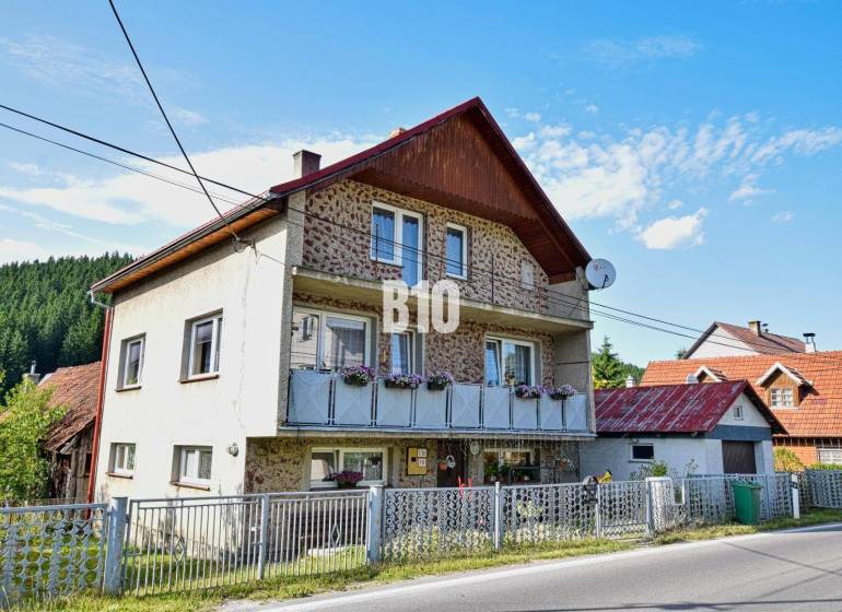 A family house in Turzovka with flowers on the balcony and a satellite dish.