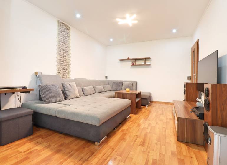 Living room in a 3-room apartment with a comfortable sofa and wooden flooring.