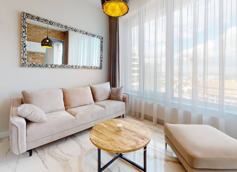 A bright living space with a comfortable sofa and a large mirror in a 2-room apartment.