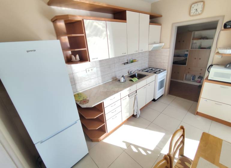 The kitchen of a 3-room apartment with white appliances and a kitchen unit.