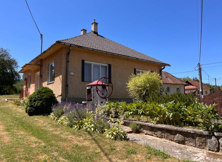 Family house on a street in Slovenská Kajňa with a landscaped garden and a well.