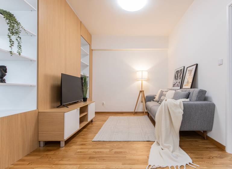 Living room with a TV, gray sofa, and decorative elements in a 3-room apartment.