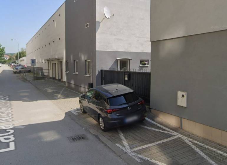 Cars parking near the building on Laco Novomeský Street in Pezinok, near the garages.