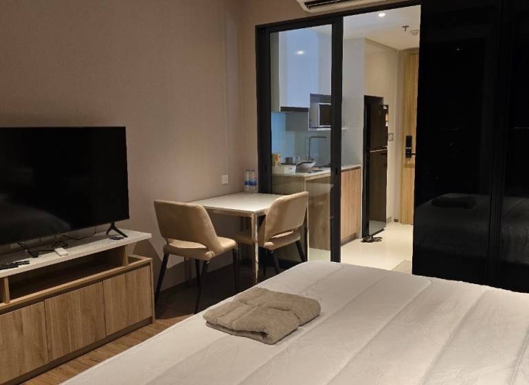 1-bedroom apartment with TV, bed, table, kitchenette, and air conditioning.