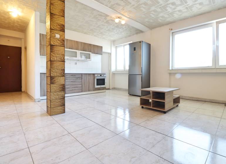 Spacious kitchen with built-in appliances in a 2-room apartment, tiles, large windows.