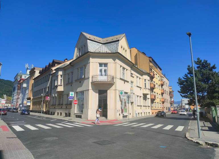 Intersection on Milcova Street in Žilina with commercial spaces and surrounding buildings.